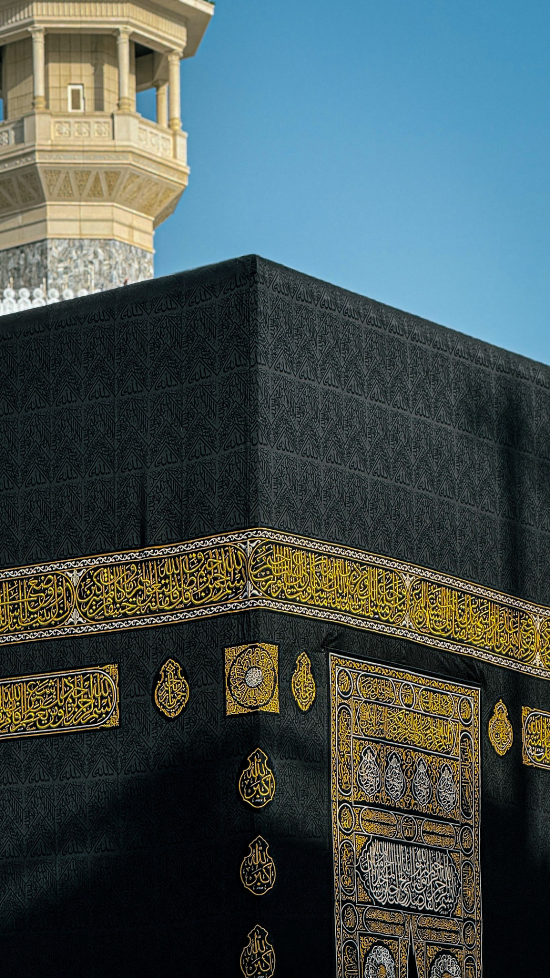 Corner of the Kaaba with gold calligraphy on the black kiswah